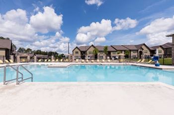 A swimming pool in front of a row of houses.