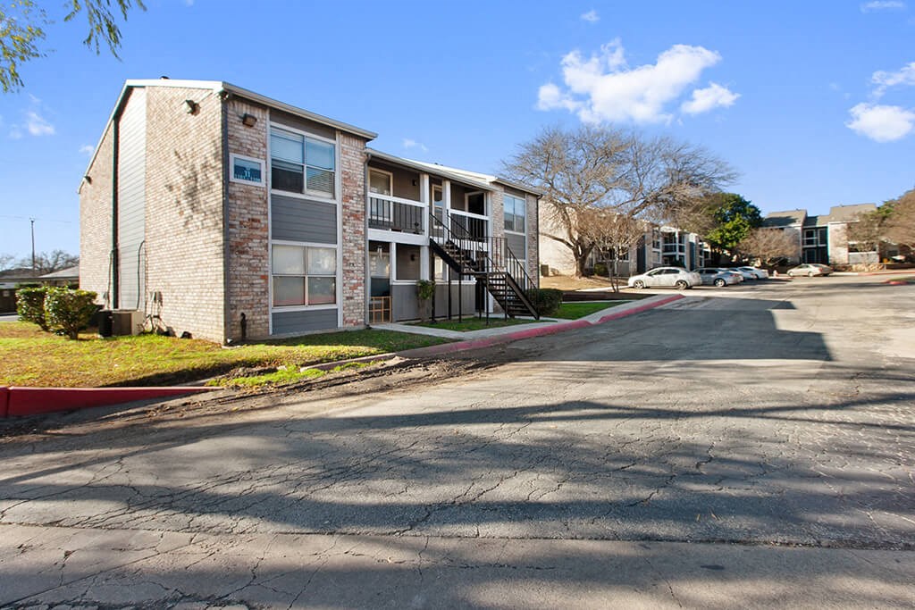 an apartment building with a street in front of it