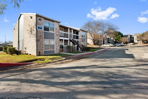 an apartment building with a street in front of it