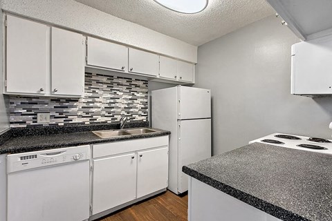a kitchen with white appliances and granite counter tops