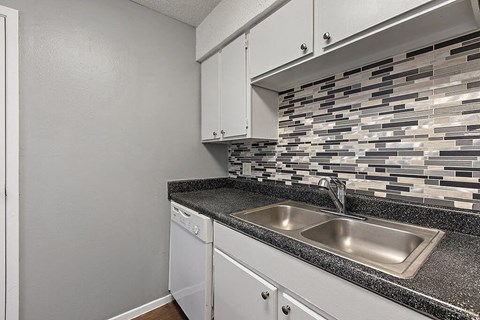 a kitchen with a sink and white cabinets