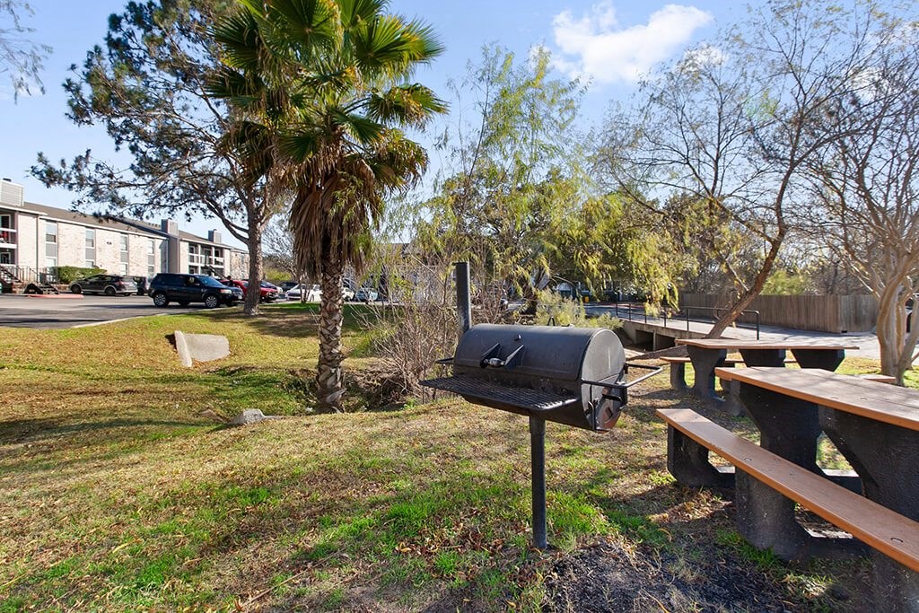 a barbecue grill in a park with benches