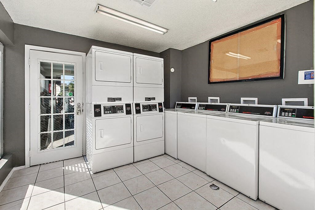 a laundry room with several washer and dryer machines