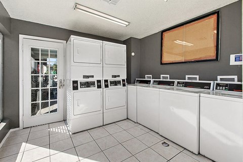 a laundry room with several washer and dryer machines