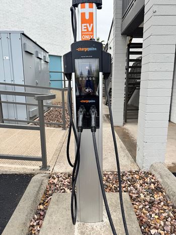 A ChargePoint electric vehicle charging station sits on a sidewalk.