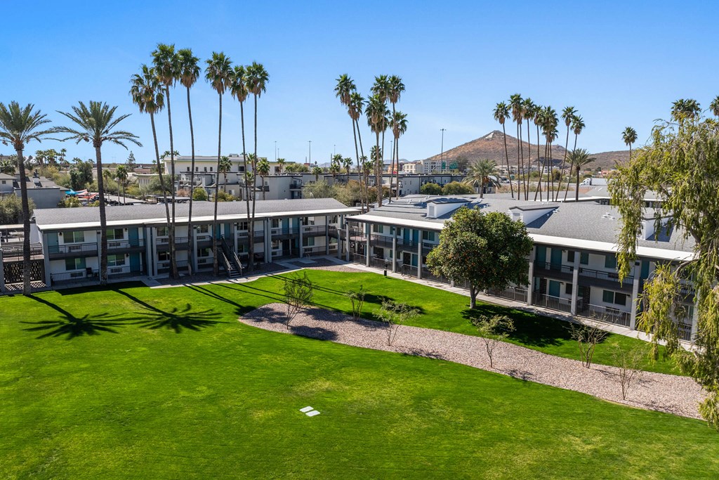 A large building with a green lawn in front of it at Presidio Palms Apartments, Tucson