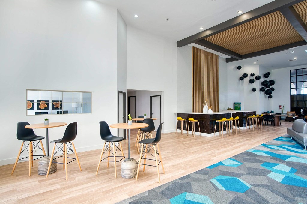 a lobby with tables and chairs and a bar at Presidio Palms Apartments, Arizona