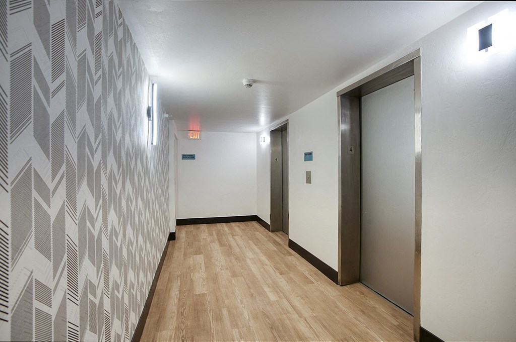 A hallway with a wooden floor and a wallpapered wallat Presidio Palms Apartments, Arizona, 85701
