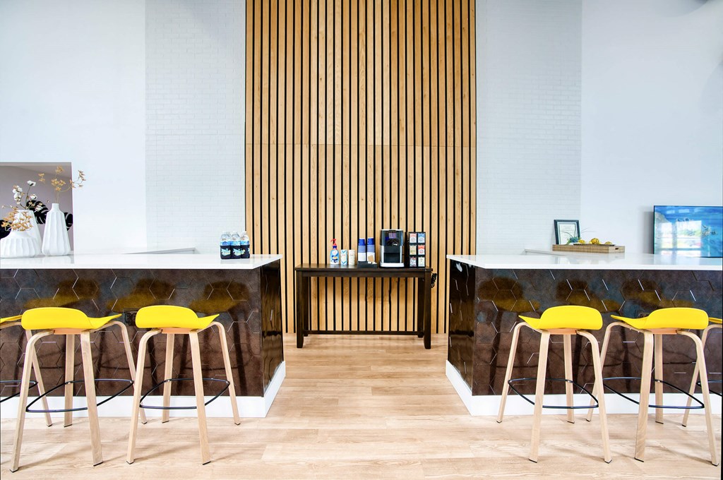a cafe with yellow chairs and marble counters and wood floors at Presidio Palms Apartments, Arizona, 85701