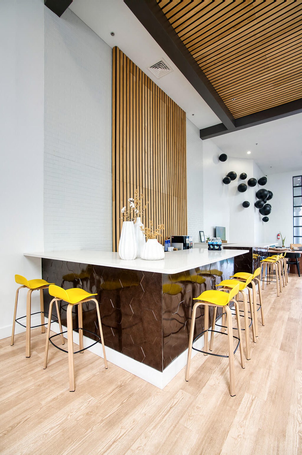 a bar with yellow chairs and a marble counter in a restaurant at Presidio Palms Apartments, Arizona