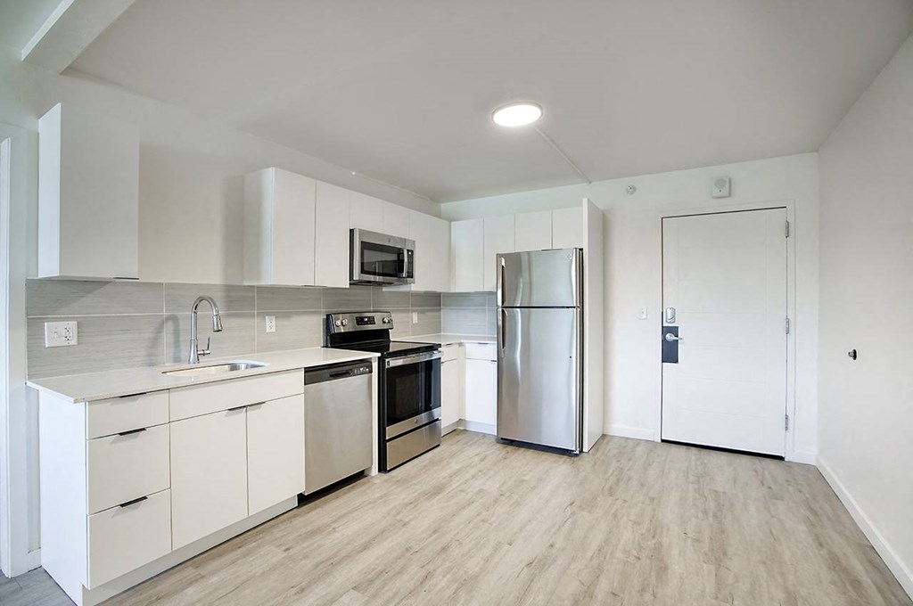 A modern kitchen with white cabinets and stainless steel appliances at Presidio Palms Apartments, Tucson, AZ