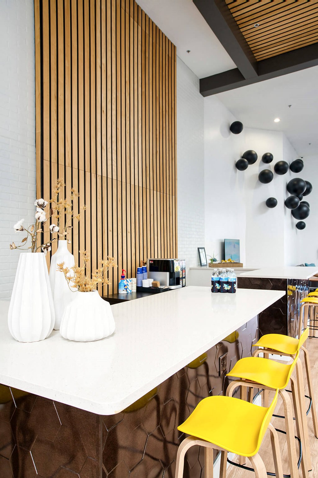 a long white counter with yellow bar stools and yellow chairs at Presidio Palms Apartments, Arizona
