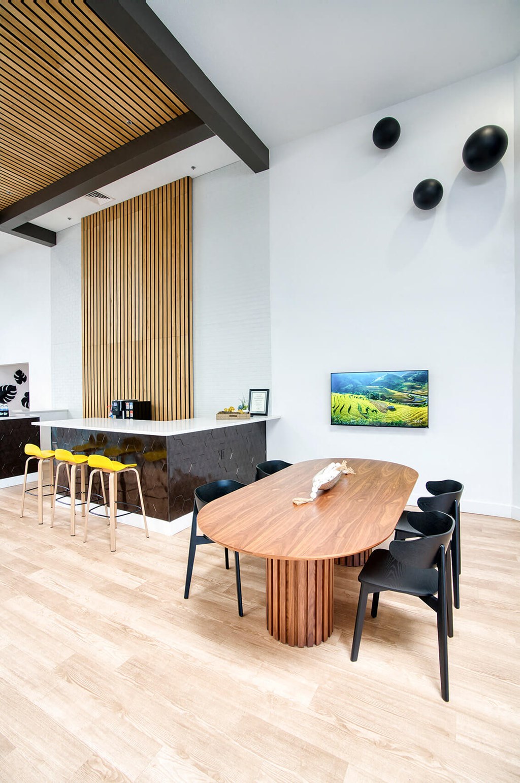 a dining room with a wooden table and black chairs at Presidio Palms Apartments, Tucson