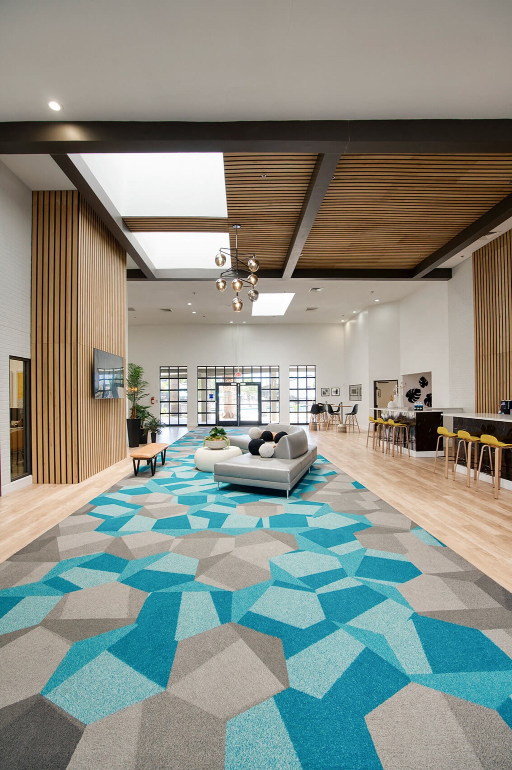 the lobby of a building with a blue rug and furniture at Presidio Palms Apartments, Tucson, 85701