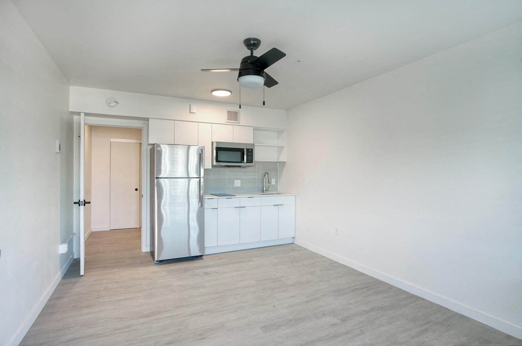 a renovated kitchen with white cabinets and a stainless steel refrigerator at Presidio Palms Apartments, Arizona , 85701