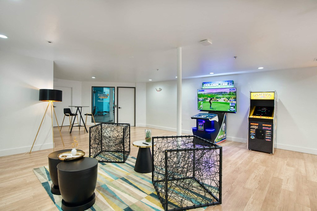 a living room with a tv and a video game on the wall at Presidio Palms Apartments, Tucson, AZ