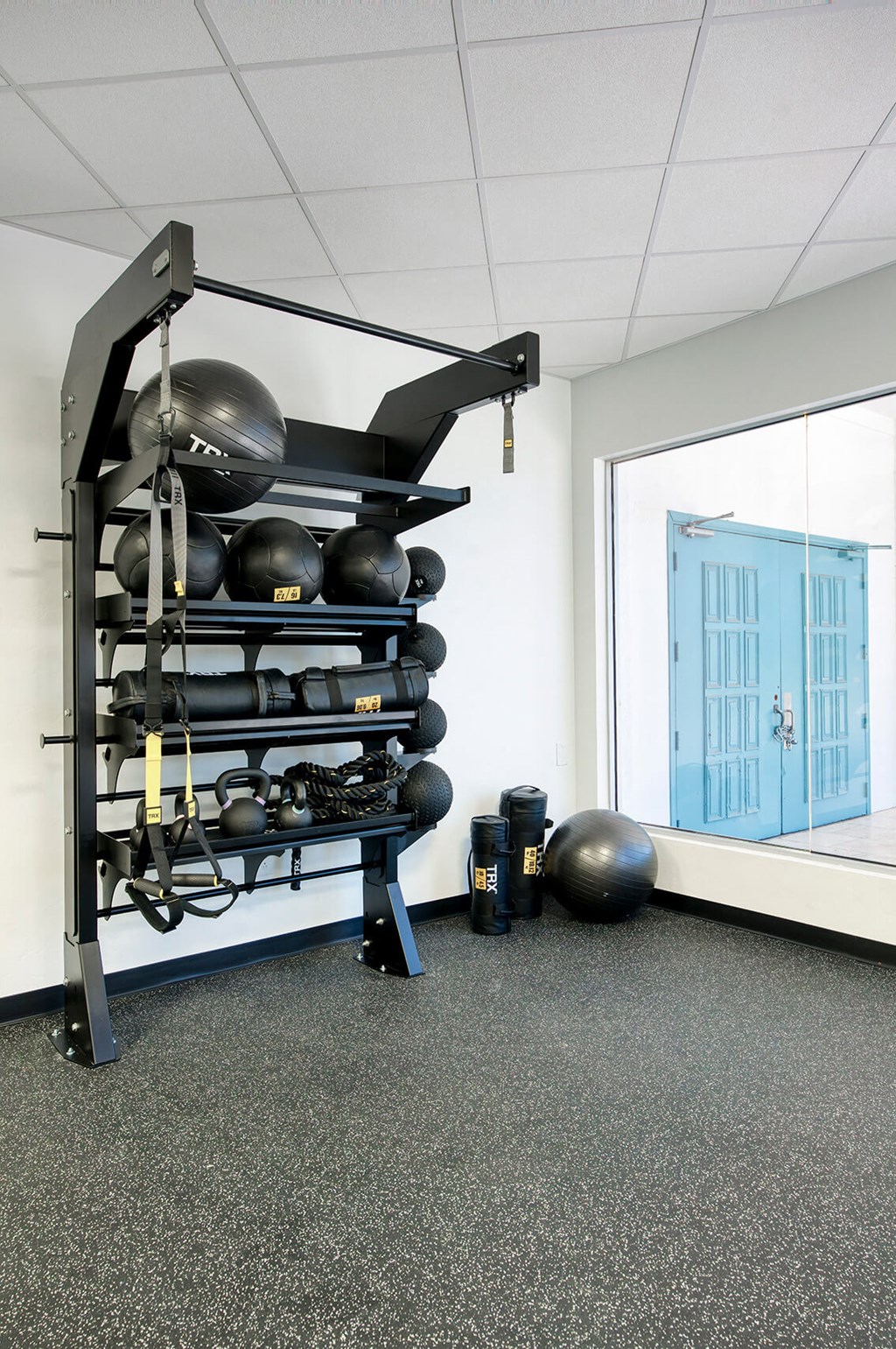 a gym with weights and a rack of balls and a window at Presidio Palms Apartments, Tucson, AZ, 85701