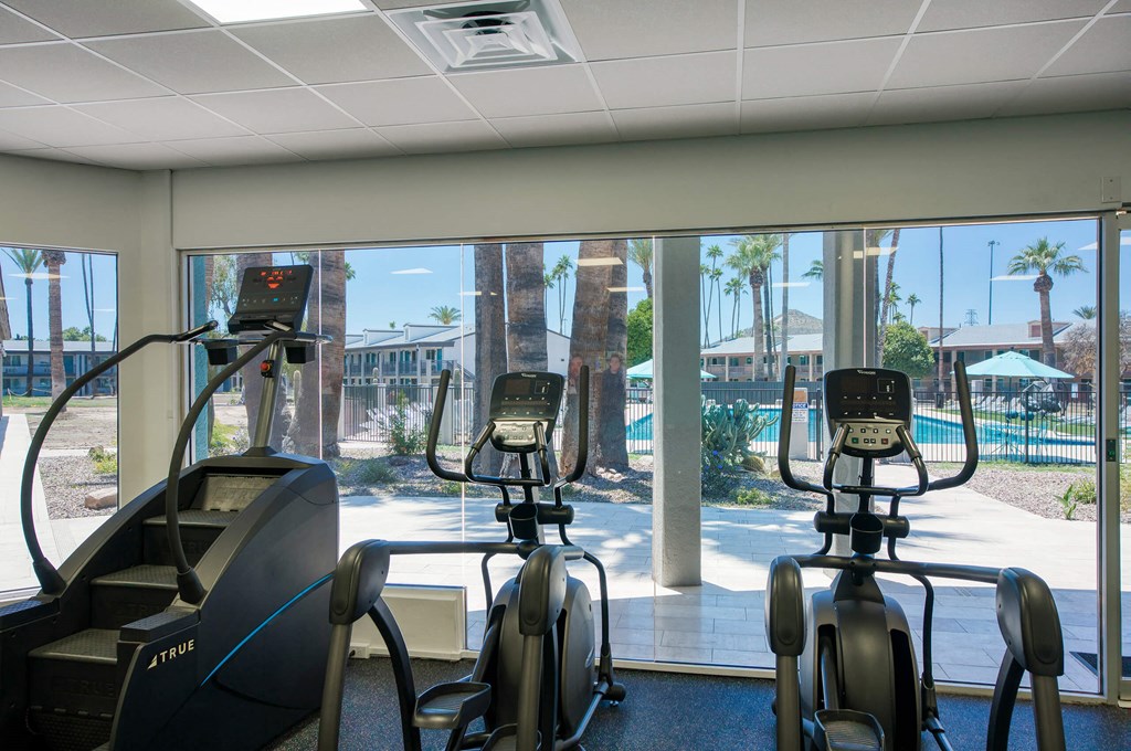 a gym with cardio machines and a view of a pool at Presidio Palms Apartments, Arizona, 85701