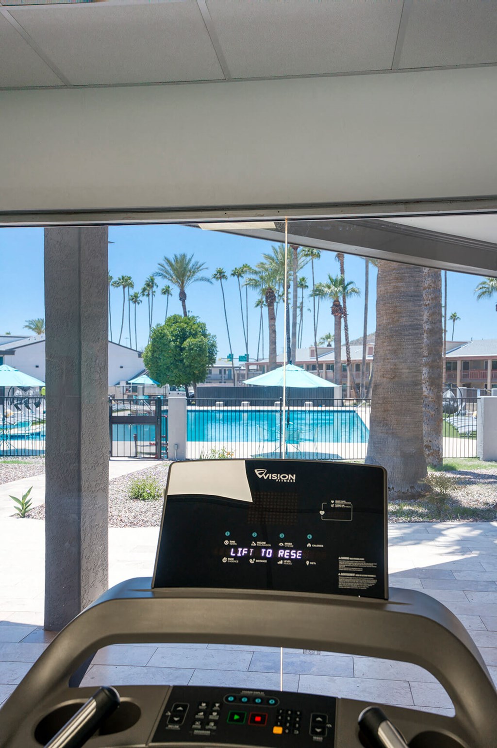 a view of a swimming pool from the inside of a treadmill at Presidio Palms Apartments, Tucson, 85701