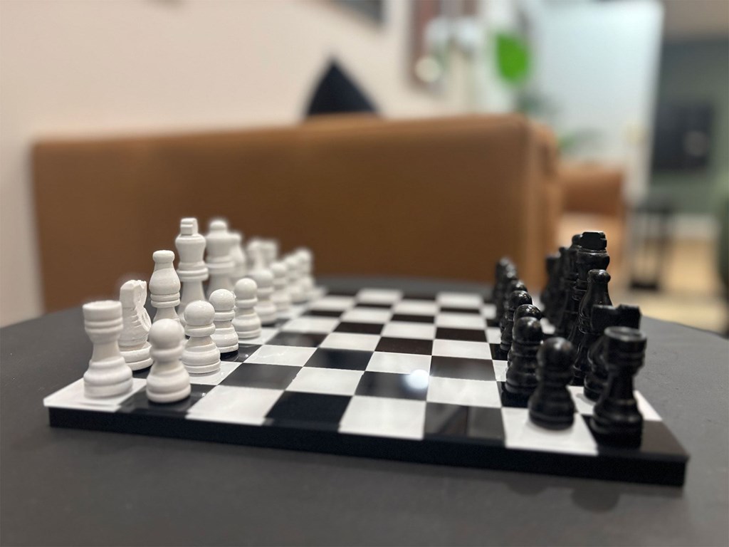 A chessboard with a black pawn and white pawn in the middle of the game.