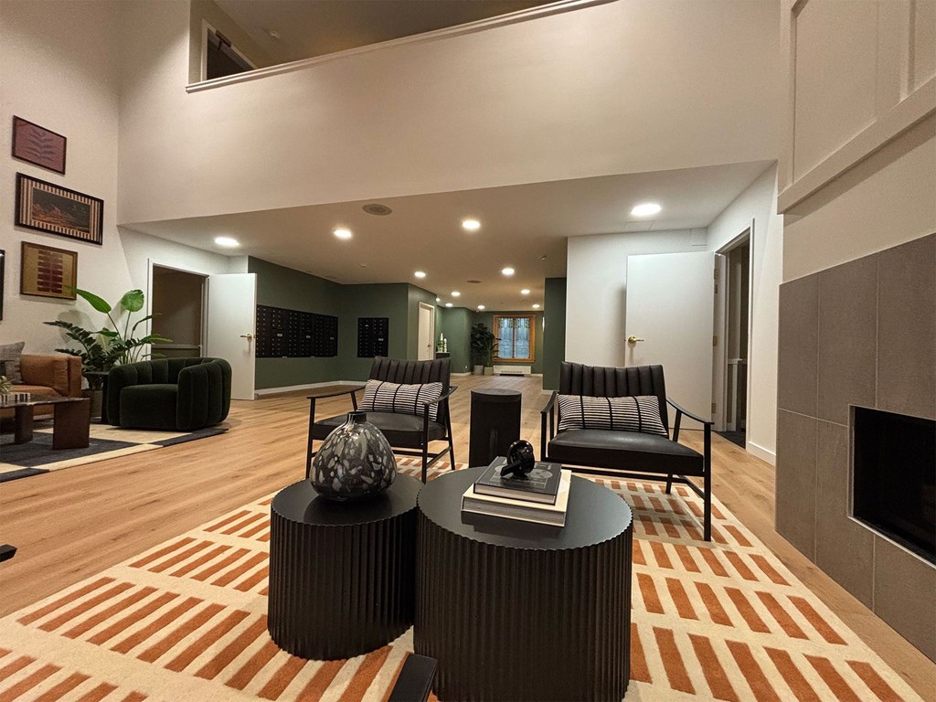 A living room with a fireplace and a striped rug.