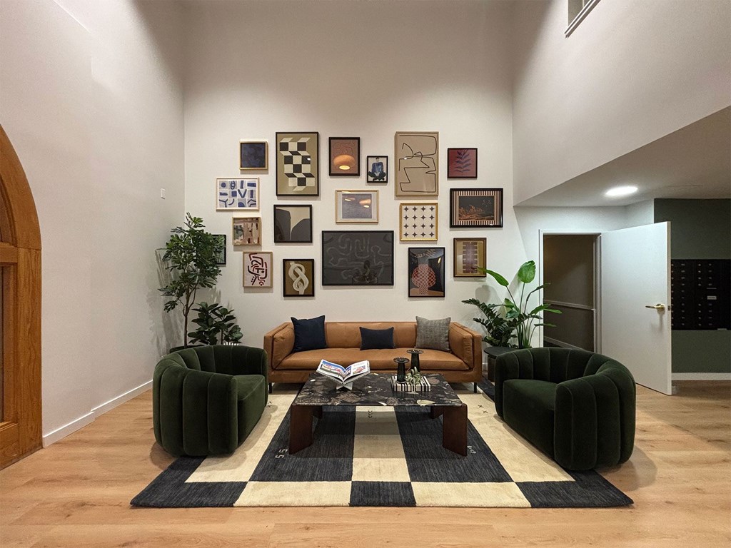 A living room with a brown sofa and a coffee table with a black and white rug.