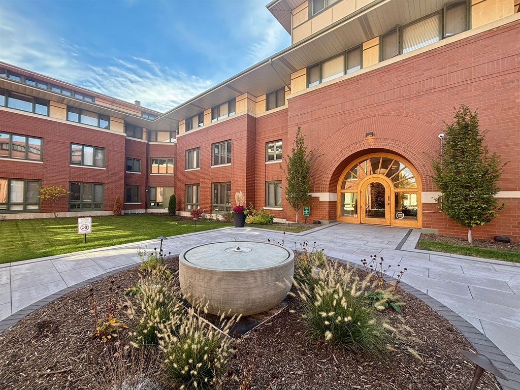 A large building with a circular planter in front of it.