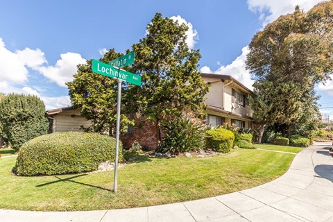 a street sign is in front of an apartment building