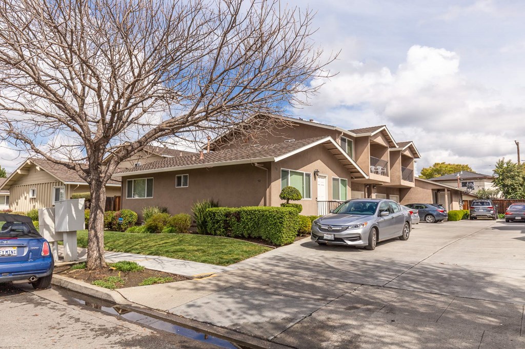 a brown house with cars parked in front of it
