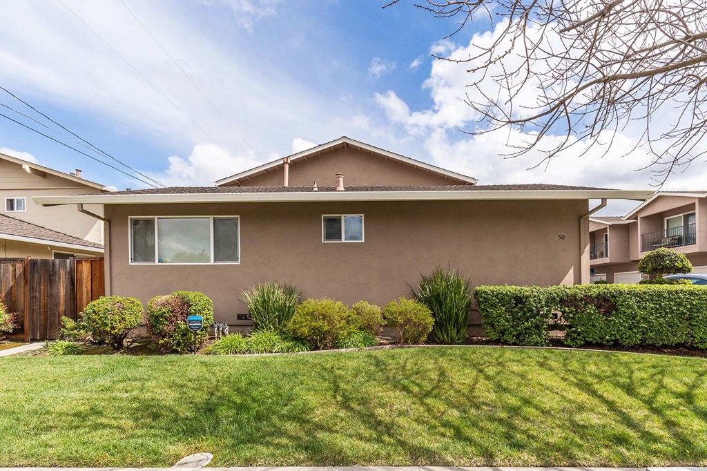 a brown house with a lawn in front of it