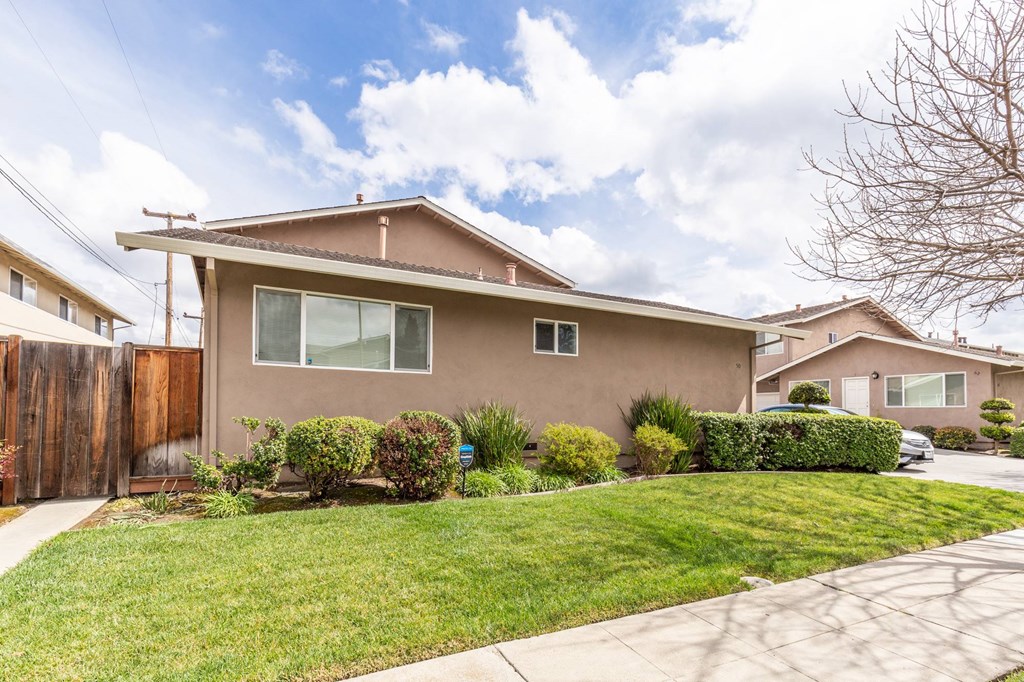 a house with a lawn and a sidewalk in front of it