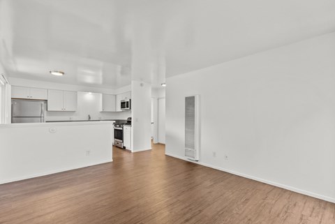 A large empty room with wooden floors and white walls.