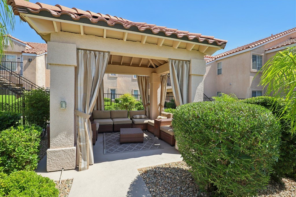 A gazebo with couch to relax near the pool