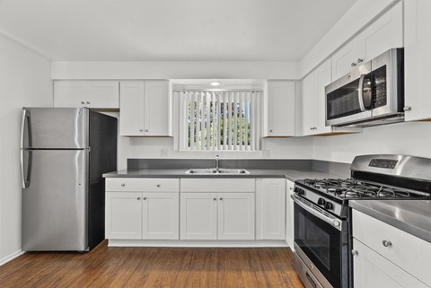 A kitchen with white cabinets and stainless steel appliances.