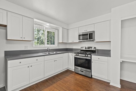 A kitchen with white cabinets and a stainless steel oven.