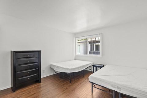 A bedroom with multiple beds and dressers