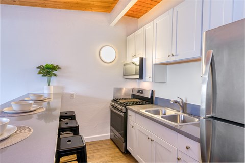 A kitchen with white cabinets and stainless steel appliances.