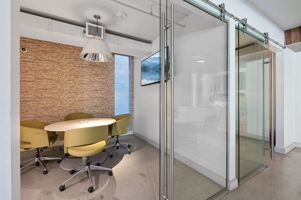 A conference room with a glass wall and yellow chairs.
