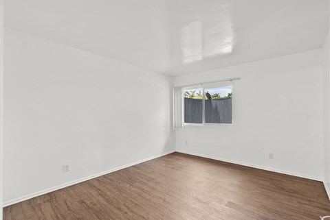 Empty room with wooden floor and white walls.