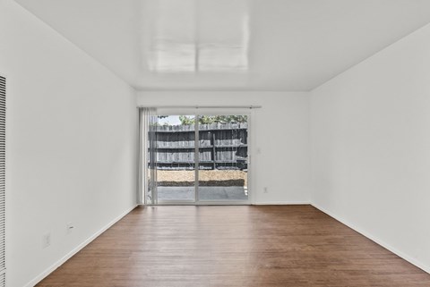 A living room with sliding door leading to  a patio