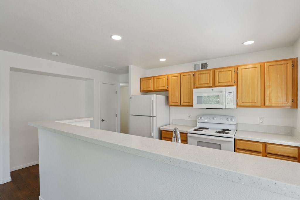 A kitchen with wooden cabinets and white appliances.