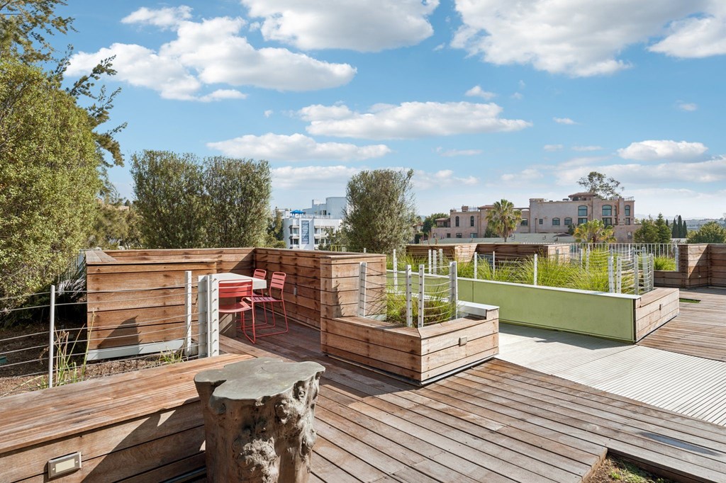 A wooden deck with a table and chairs overlooking a cityscape.