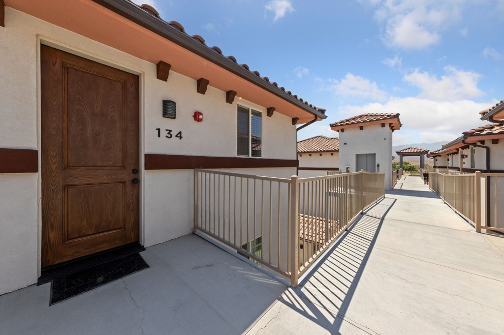 A balcony with a wooden door and railing.
