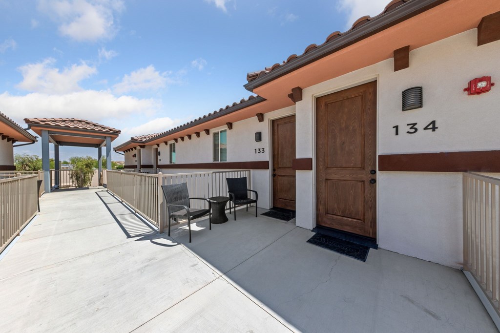 View of the front door of an apartment with patio chairs