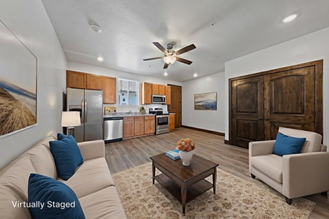 A living room with a couch, a chair, a coffee table, and a painting on the wall.
