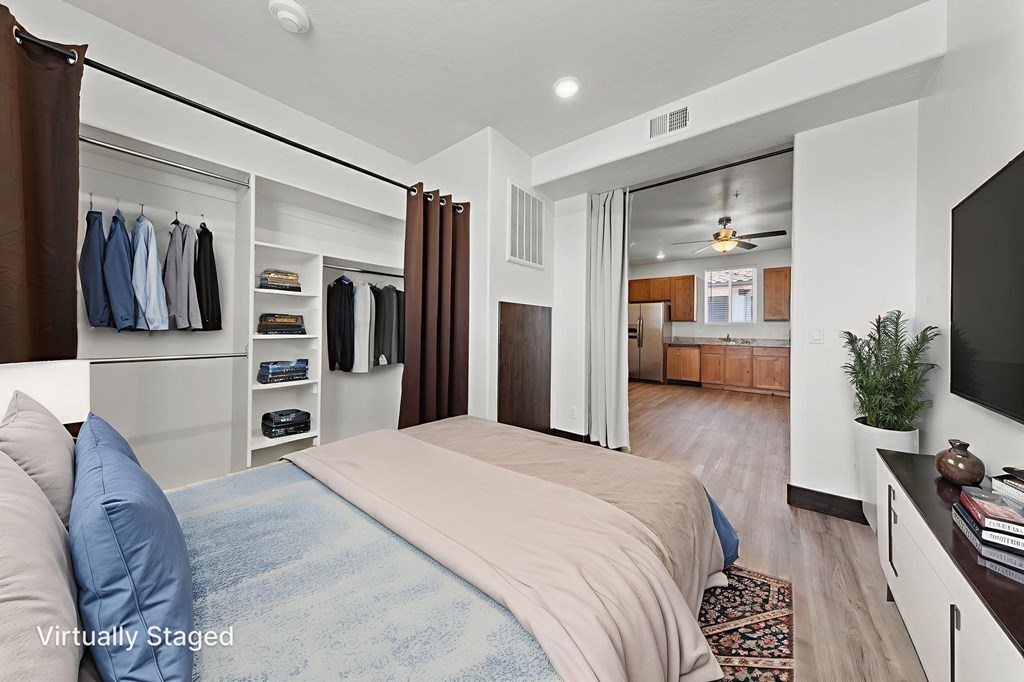 A bedroom with a bed, a TV, and a wardrobe.