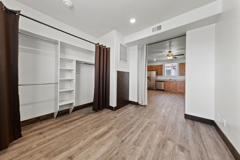 A room with a brown carpet and wooden flooring.