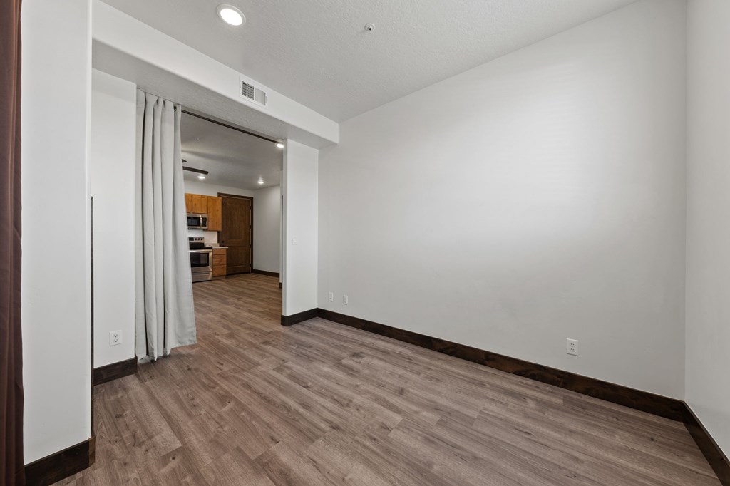 A room with wooden flooring and white walls.