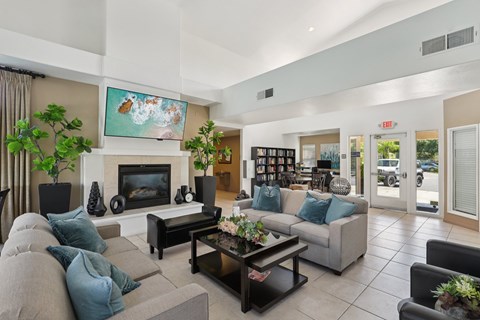 A living room with a grey couch, a coffee table, and a fireplace.