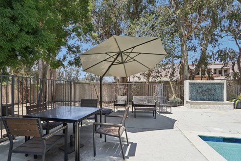 A patio with a table and chairs under an umbrella.